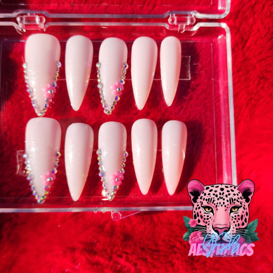 A set of press-on nails in a white French manicure style with gemstone accents, displayed in a clear case. White Frenchies Gems Luxurious Press On Nails made by YSB Aesthetics LLC.